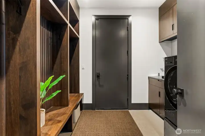 Functional utility space with built-in storage, washer and dryer, and sink. Door provides convenient access to the attached garage.