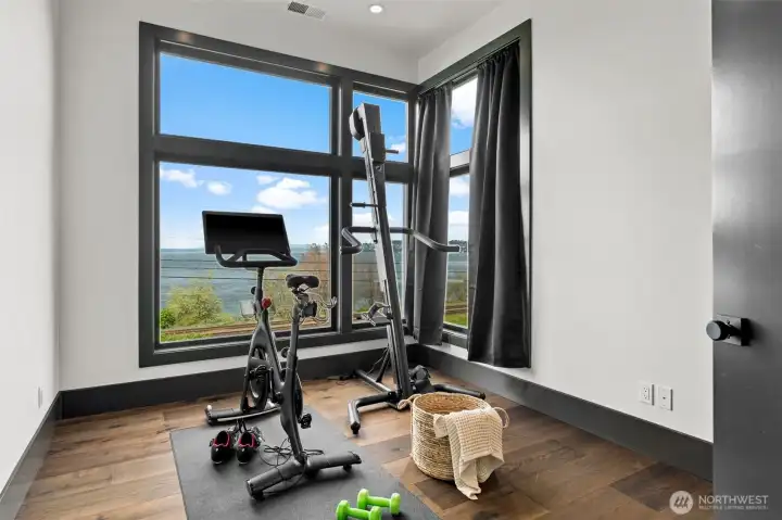 Flexible room with large windows and water views, ideal for fitness, office, or additional living space.