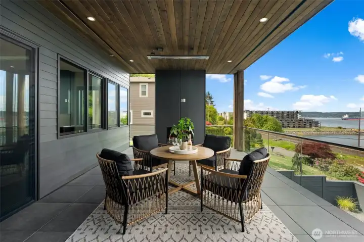 Covered outdoor living area with seating, overlooking Ruston and the water.