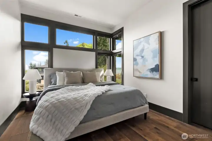 Upper-level bedroom with large windows and abundant natural light.