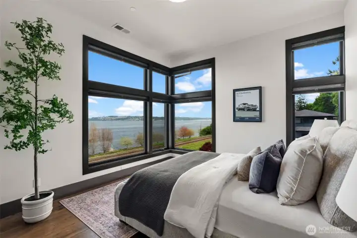Additional upper-level bedroom with corner windows showcasing water views.
