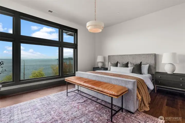 Refined primary suite with water views, a spacious layout, and a seamless connection to the en suite bathroom.