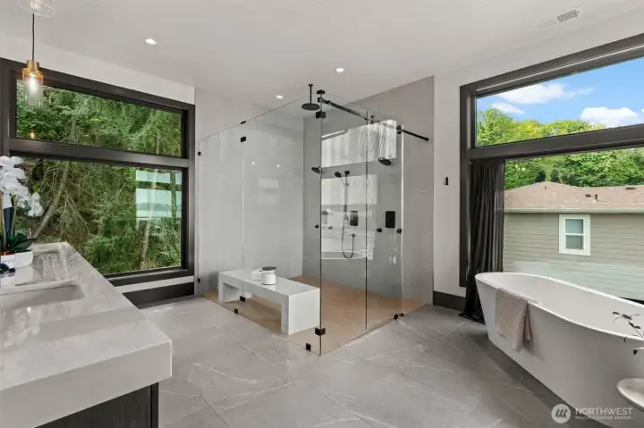 Spa-like primary en suite with glass walk-in shower, freestanding soaking tub, dual vanities, and refined finishes throughout.