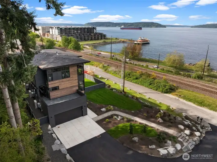 Elevated setting captures panoramic water views with a fully fenced yard, landscaped grounds, and an attached garage.