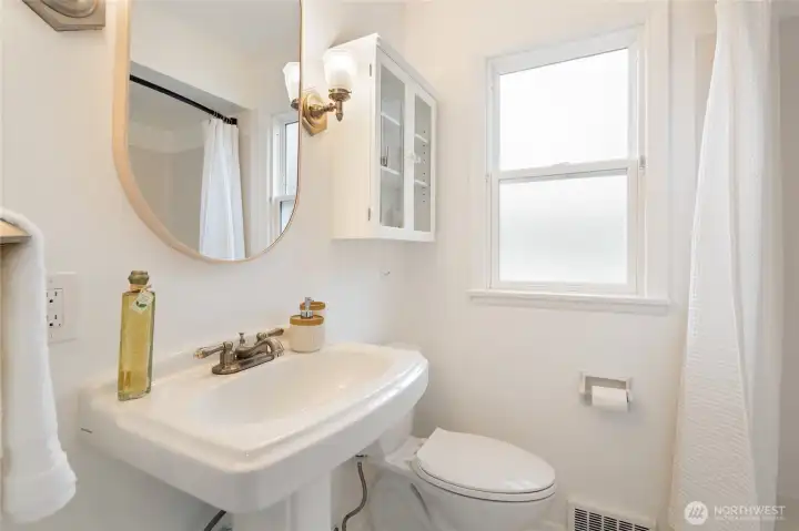 Full bathroom on the main level with classic hex tile floors.