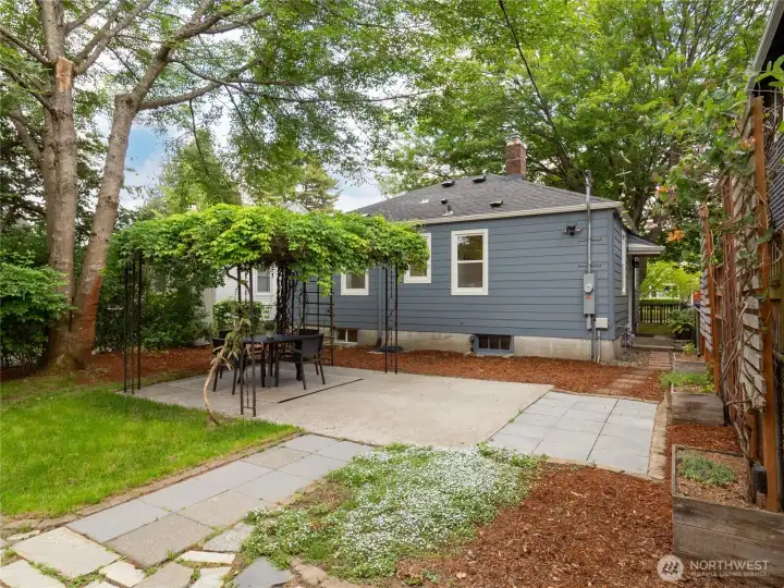 The patio with a vine-covered arbor adds a bit of fairytale magic to the space.