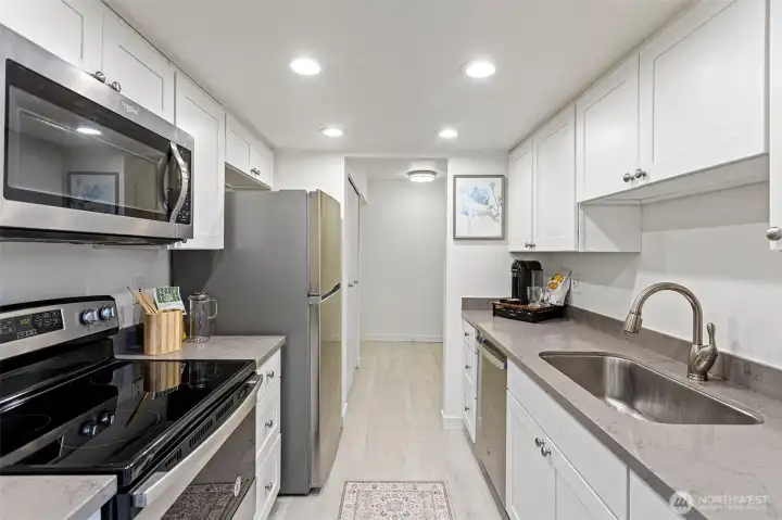 The kitchen includes a dishwasher, microwave, range/oven, and a new refrigerator, offering everyday convenience and functionality.
