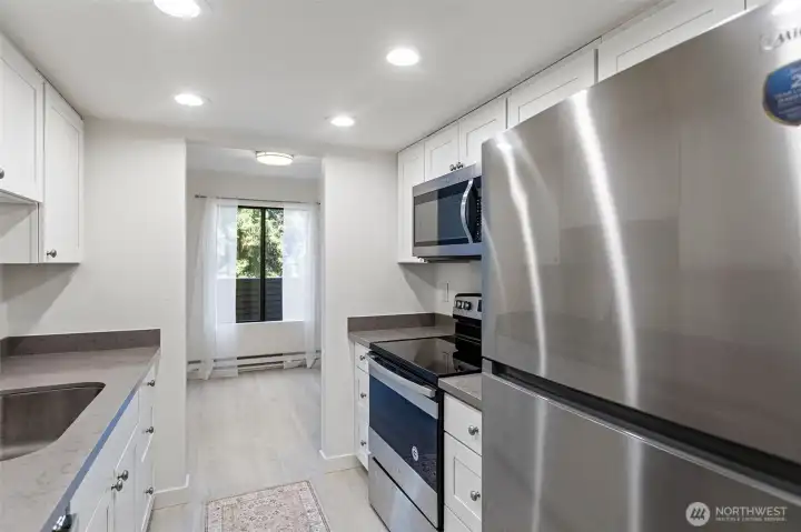 The kitchen includes a dishwasher, microwave, range/oven, and a new refrigerator, offering everyday convenience and functionality.