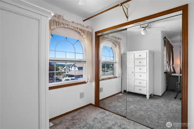 Large mirrored closet off primary bedroom and partial water view