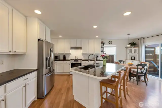 Generous kitchen with stainless appliances, prep island and access to backyard