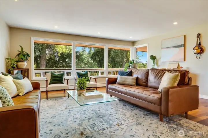 This formal living room with hardwood floors, a gas fireplace, built-ins, and views into the trees is the sellers' favorite spot in the house.