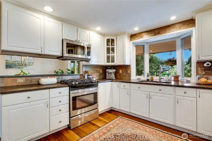 Bar counters at each end of the kitchen give the room its own sense of space while connecting it to the dining room and family room. A tile backsplash compliments the quartz counters and the undermount sink makes for easy clean-up.