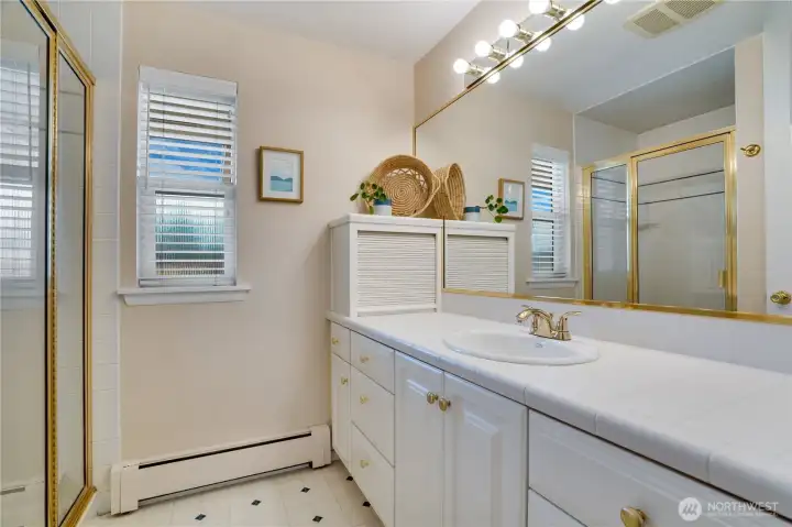 This 3/4 ensuite bath offers a tiled shower and a vanity with plenty of cupboards and drawers for storage.