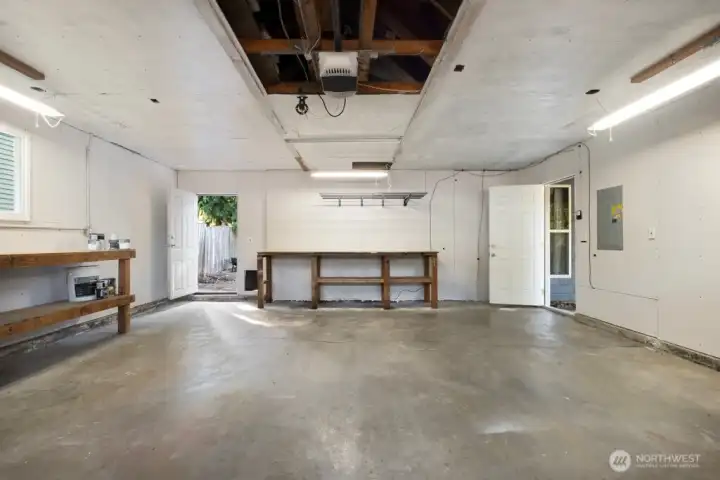 Large two-car garage offers shop space, attic storage, and direct backyard access