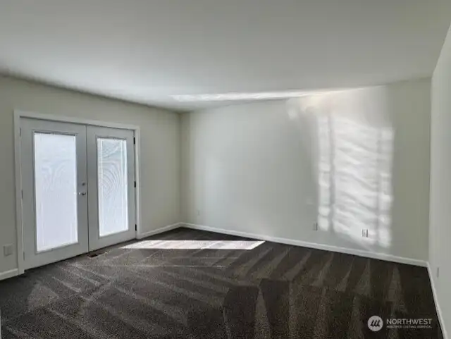Primary bedroom with beautiful double doors leading to the outside.