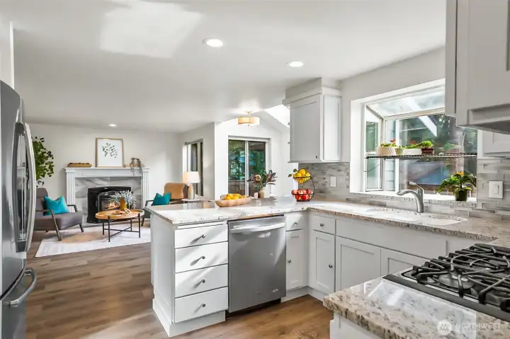 Kitchen has granite counters and full height tile backsplash