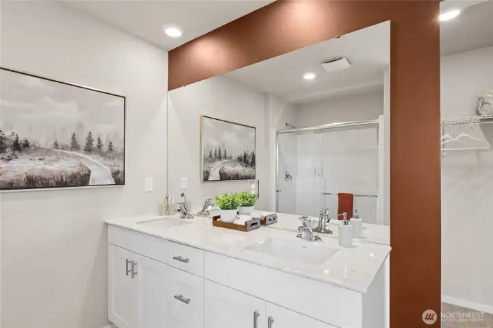 Double vanity in the primary bathroom. Actual home is under construction and finishes, colors, and materials may vary. See site agent for details.
