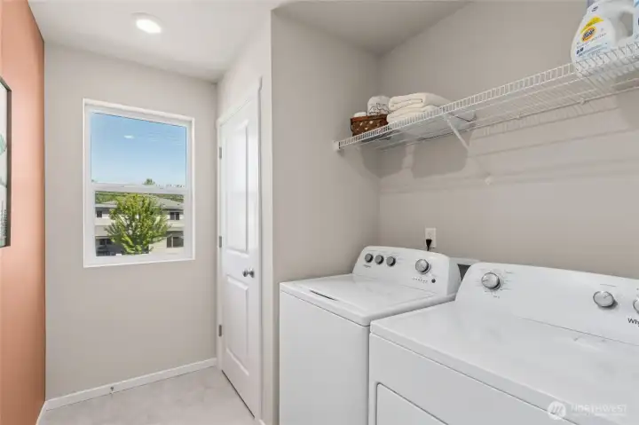 Dedicated laundry room with a window for natural light. Actual home is under construction and finishes, colors, and materials may vary. See site agent for details.