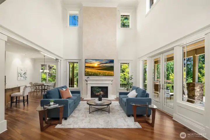 Family room w/ open floor plan has vaulted ceilings, fireplace, opens to patio & kitchen.