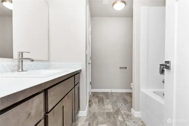 upstairs full hall bath with more storage area