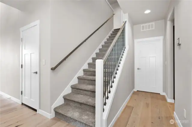 stairway to 2nd floor with metal and wood railings