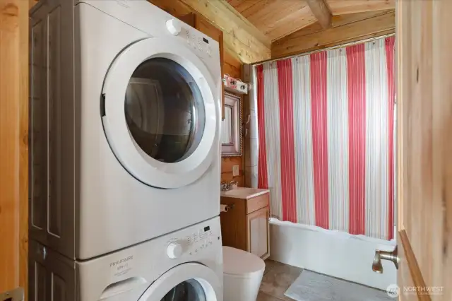 Full bath with stack unit washer & dryer.
