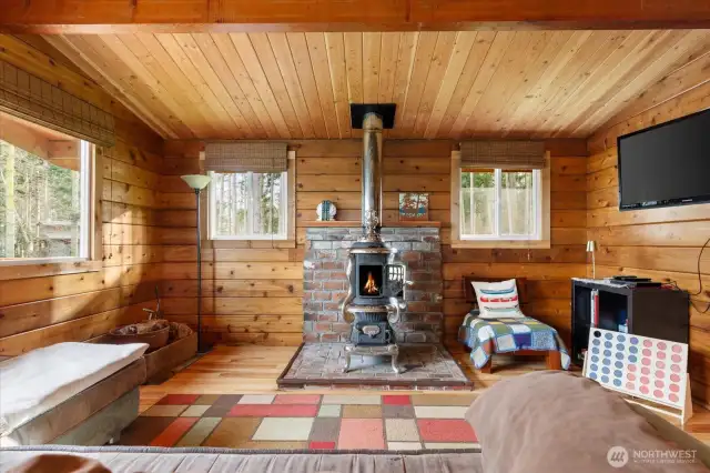 Great room with vaulted tongue-and-groove cedar ceiling. Stay toasty with the heat from this refurbished antique pot-belly wood-burning stove. There's nothing like drawing close and listening to the crackling fire in this cozy space.