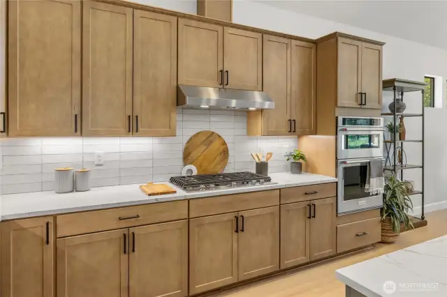 Gourmet kitchen with gas cooktop and stainless steel extraction hood.