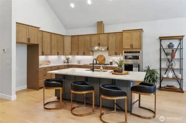 Gourmet kitchen with gas cooktop and stainless steel extraction hood.