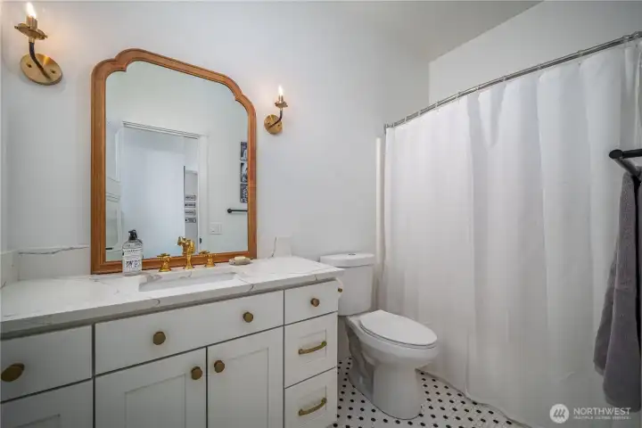 It features penny tile floors, quartz counters, and bronze finishes.