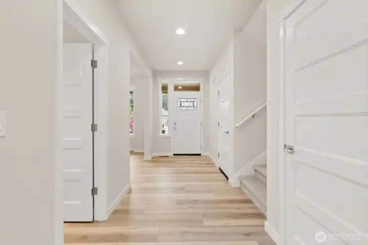 Welcome home! Open and inviting entry way. The front door with transom window above, allowing natural light to stream in and brighten the space.