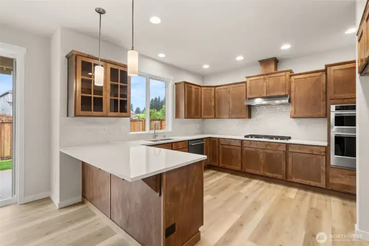 Kitchen- appliances include microwave/oven combo, gas cooktop w/overhead vent hood & dishwasher.