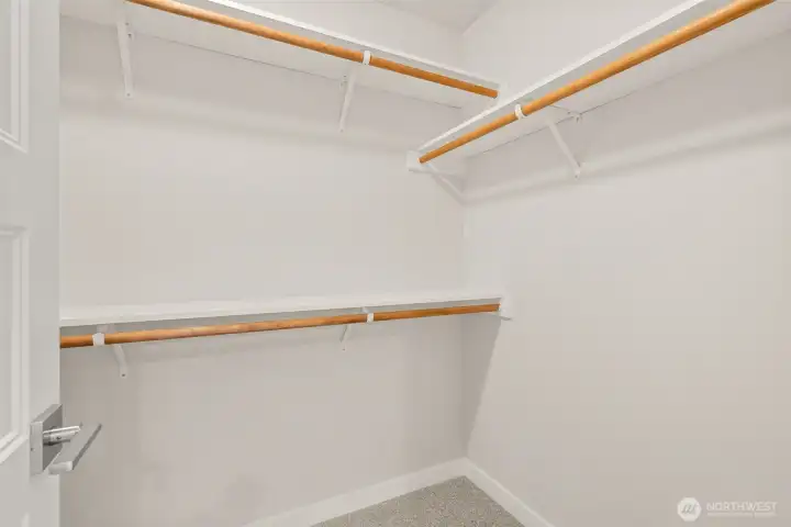 Primary bedroom features a walk-in closet with solid shelving.