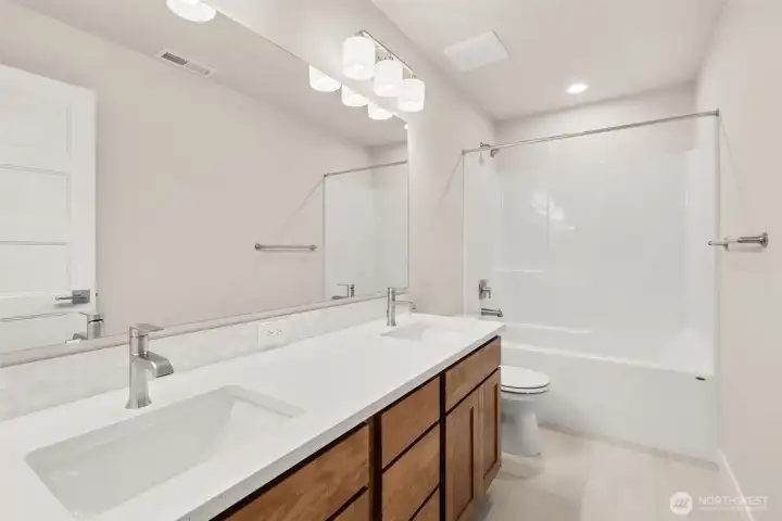 Main bathroom with dual sink vanity and quartz countertops.