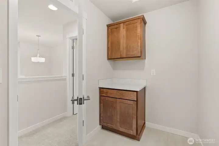 Upper and lower cabinets in laundry room.