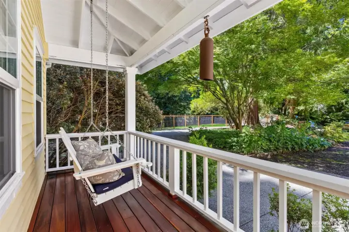 A gracious covered front porch with a sweet porch swing welcomes you home and greets your guests. This lovely porch decking was recently replaced with Tigerwood.
