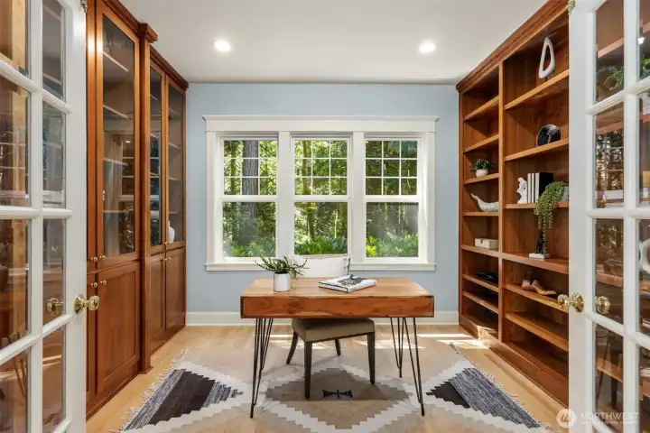 The private home office on the main floor is flanked with wood cabinetry and has French doors for nice privacy.