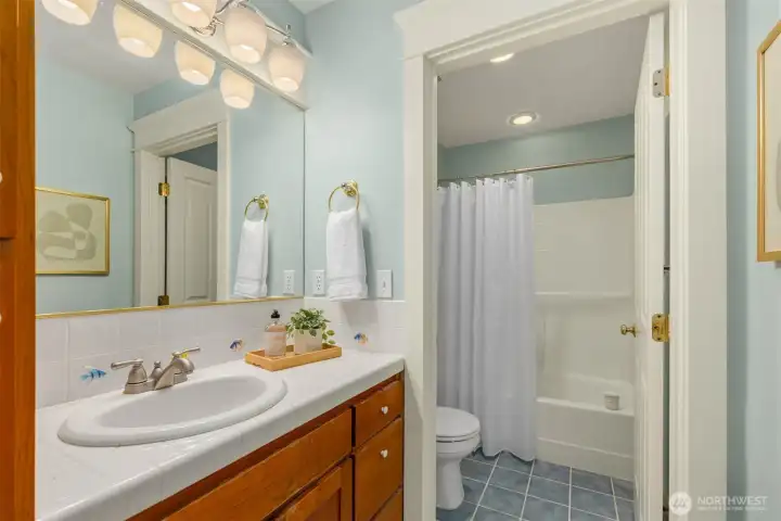 The main hallway bathroom with tiled flooring, good storage and a tub/shower combo.