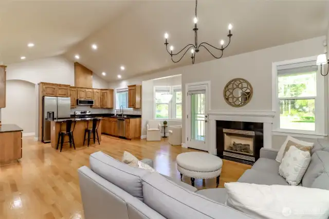The great room features vaulted ceiling, overhead lighting, a bay window, gas fireplace and access to the covered patio.