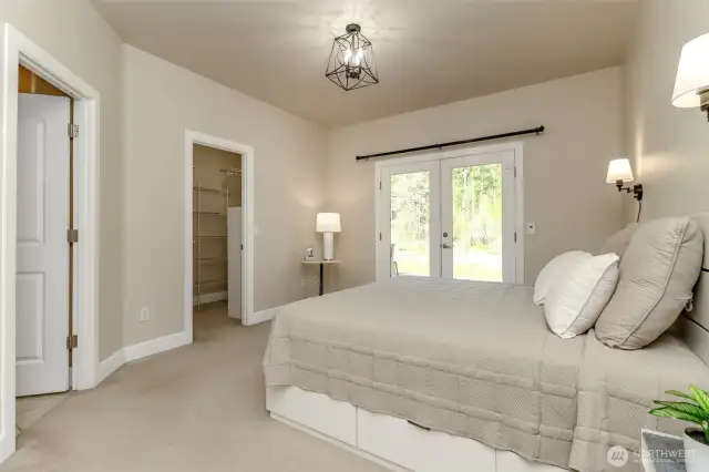 Primary bedroom with double doors leading to deck with hot tub