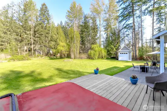 The deck off the primary bedroom has  stairs leading to the patio and the expansive lawn.