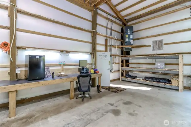 The door to the massive garage is shown in this picture.  There is a wall length of work bench/desk with plenty of outlets.  Tons of lighting-several ceiling fans and there is heating and ventilation.