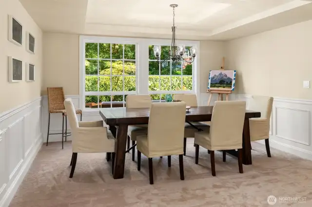 The dining room looks over the back yard space and features a coffered ceiling and classic Wainscotting accent walls.