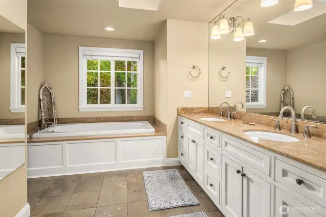 The 5-pieces en suite bath features a skylight, dual vanity with granite counters, heated tile floors, oversized shower with body jets, bench and nook, a deep jetted tub and a huge walk-in closet with a circular layout providing two accesses to this space.