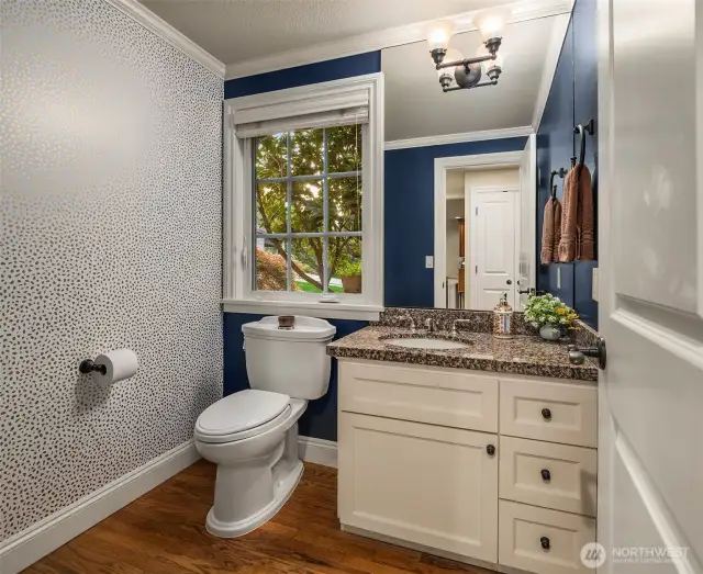 The main floor powder room displays the same attention to detail with an updated vanity, granite countertop and upgraded lighting.