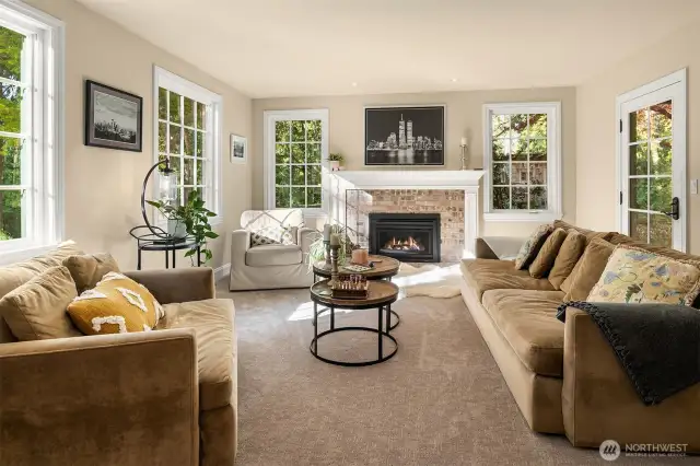 A light filled, warm, relaxing, private home.  A traditional floorplan with large rooms featuring a living room, family room, dining room and eating nook. Here is the inviting and warm living room framed by one of two fireplaces with a custom mantel and displays the details of new wood trim you see throughout the home.