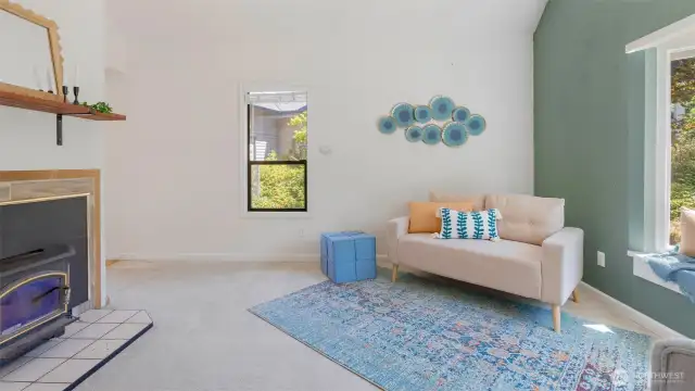 The living room welcomes you with a calming sage green accent wall and a wood-burning fireplace insert that brings the heat when winter rolls in. It’s the kind of space that feels good year-round.
