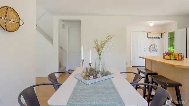 The open stairwell draws your eye upward, leading to the home’s second level. To the far right, the white door offers direct access to the garage - perfect for bringing groceries straight into the kitchen.