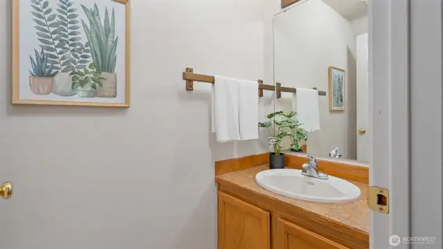 Tucked neatly at the base of the stairwell, the powder room is right where you need it - easily accessible for guests without interrupting the flow of the main living space.