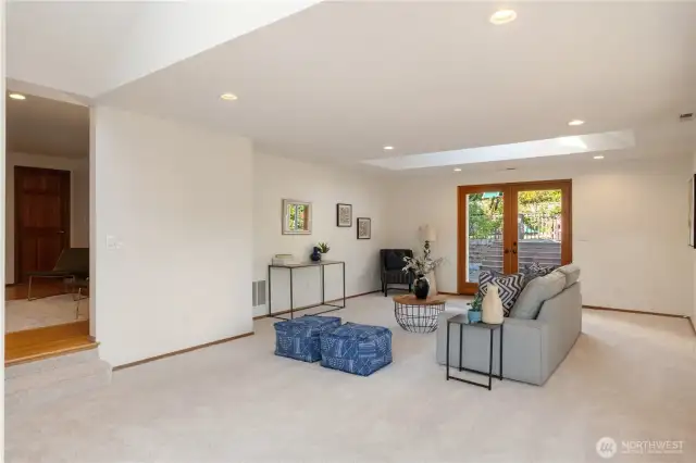 French doors lead out to partially covered deck, and elevated decking large enough for furniture for entertaining.
